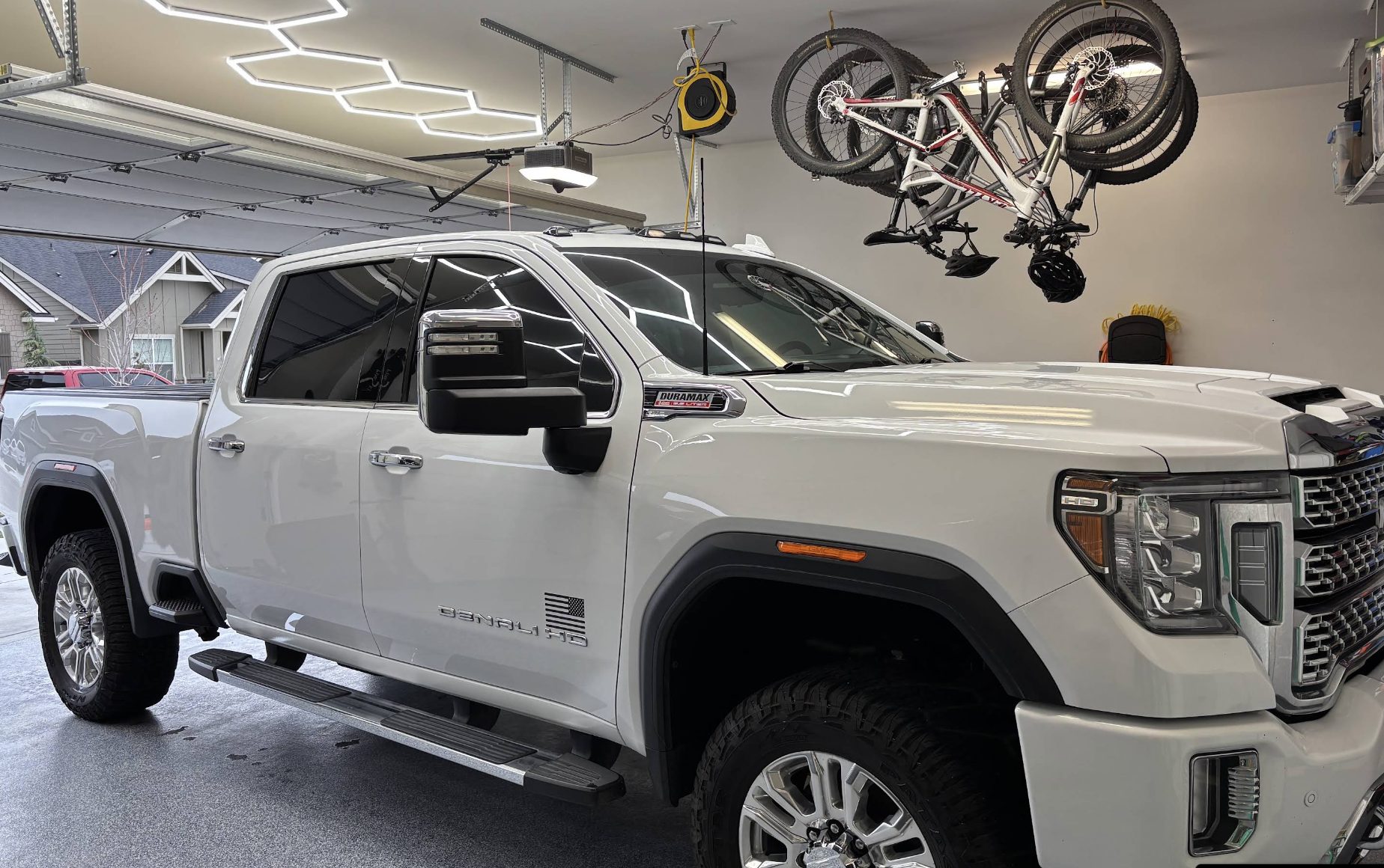 White GMC Sierra Denali HD detailed and parked in a lit garage
